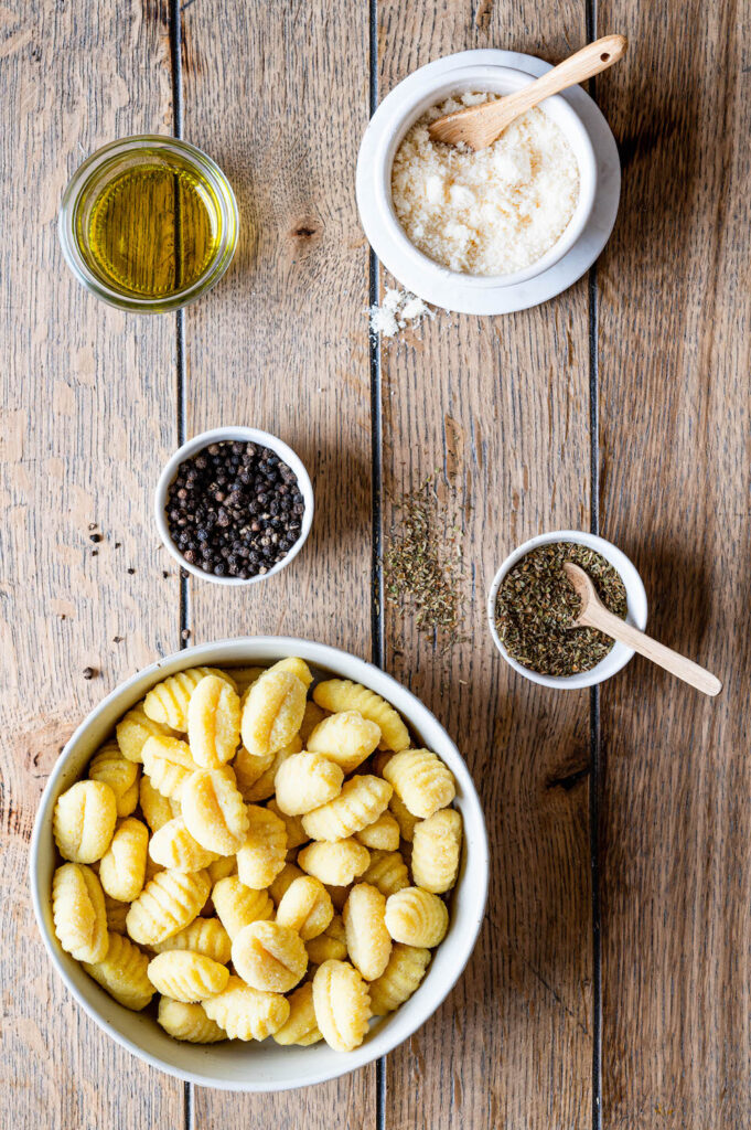 Zutaten für die Gnocchi aus der Heißluftfritteuse: Gnocchi aus dem Kühlregal, Parmesan, Kräuter, Gewürze und Olivenöl.
