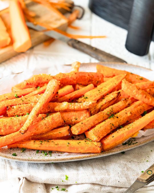 Karotten mit Parmesan aus der Heißluftfritteuse auf einem Teller.