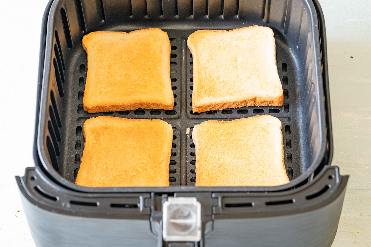 Vier Scheiben getoastetes Toastbrot im Heissluftfritteusen-Korb.